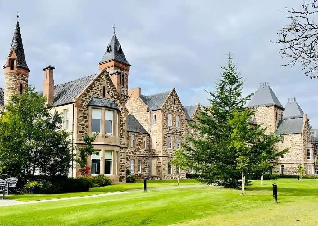 a large building with a green yard in front of it at Great Glen Townhouse Inverness - Entire 3 Story Townhouse in Inverness