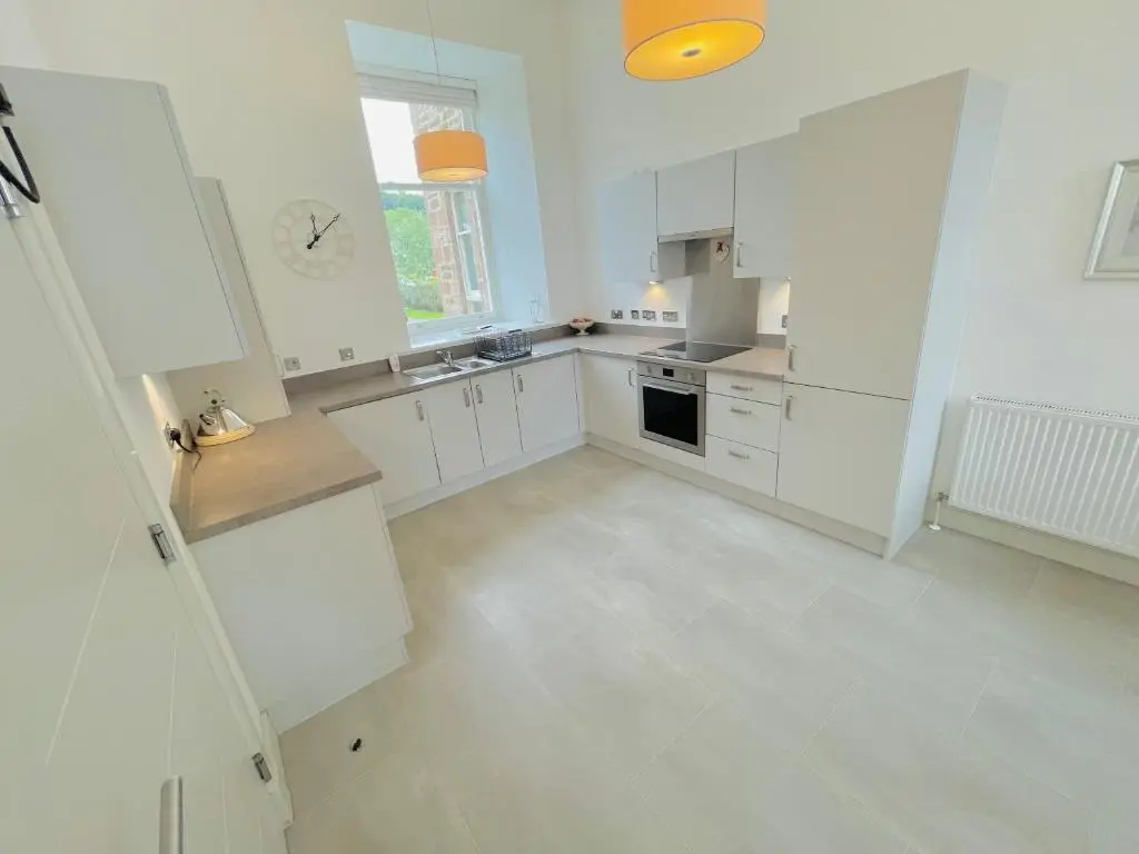 a large white kitchen with white cabinets and appliances at Great Glen Townhouse Inverness - Entire 3 Story Townhouse in Inverness