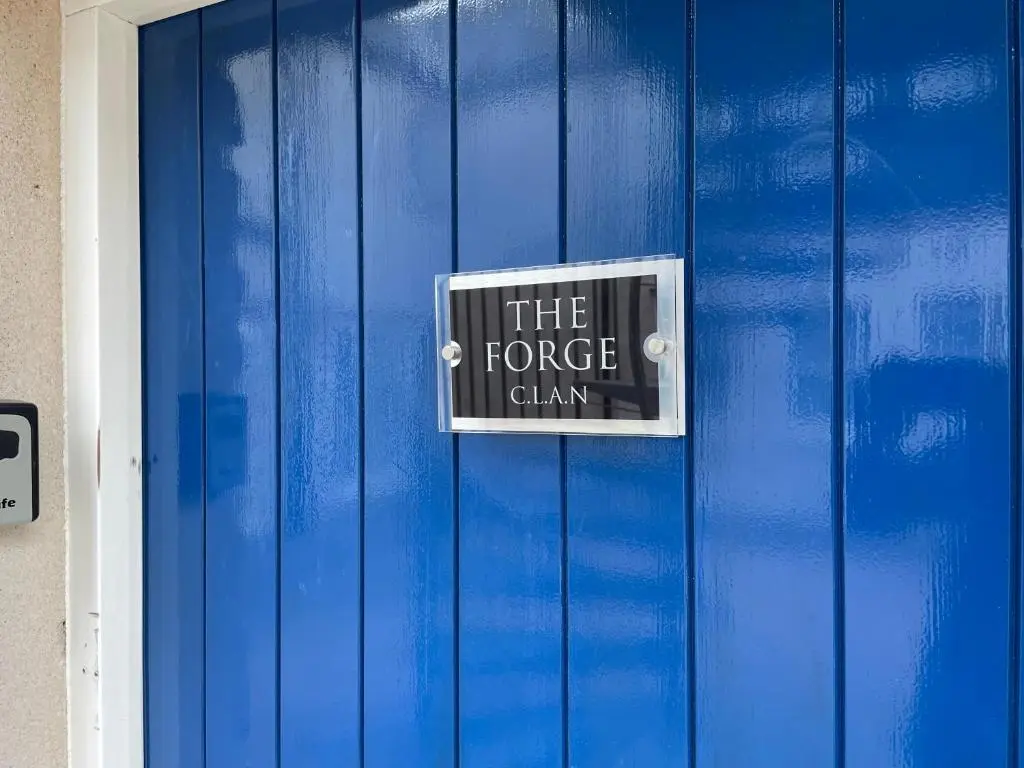 a blue door with a sign that reads the force claw at The Forge by Caithness Luxury Apartments NC500 - Elegant Luxury Apartment with Bike store - Sleeps 4 in Wick