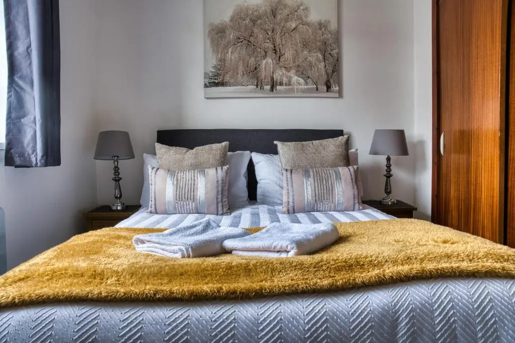a bedroom with a bed with two pillows on it at Two Bed Holiday Home with Free Parking in Inverness in Inverness
