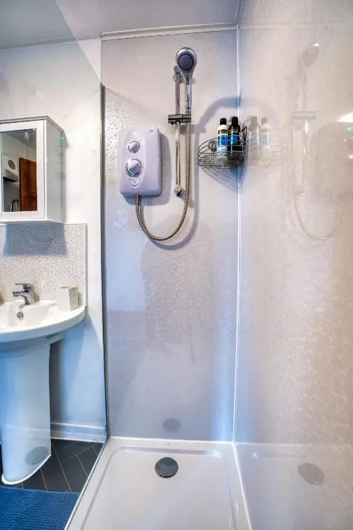 a shower with a glass door in a bathroom at Two Bed Holiday Home with Free Parking in Inverness in Inverness