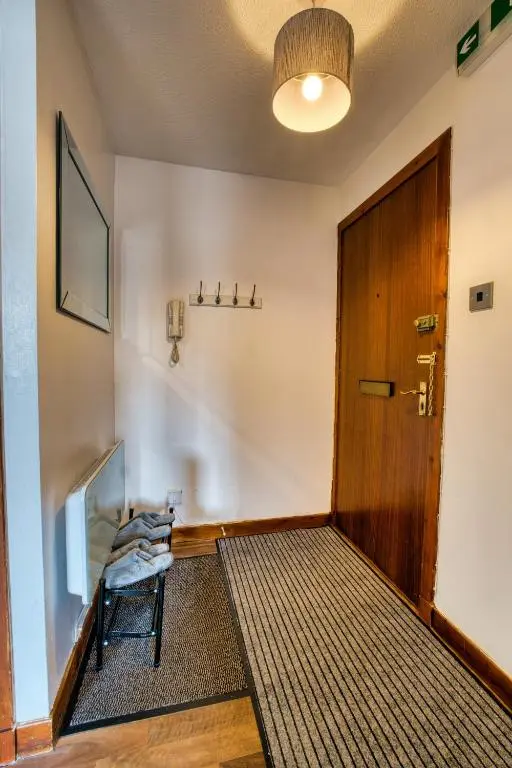 a hallway with a wooden door and a rug at Two Bed Holiday Home with Free Parking in Inverness in Inverness