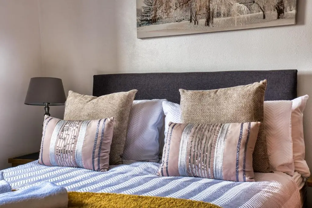 a bed with pillows on it in a bedroom at Two Bed Holiday Home with Free Parking in Inverness in Inverness