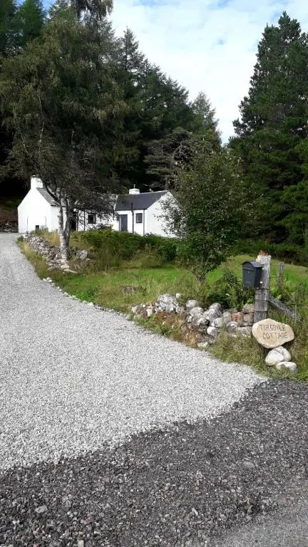 a gravel road with a house in the background at Torgoyle Cottage in Inverness