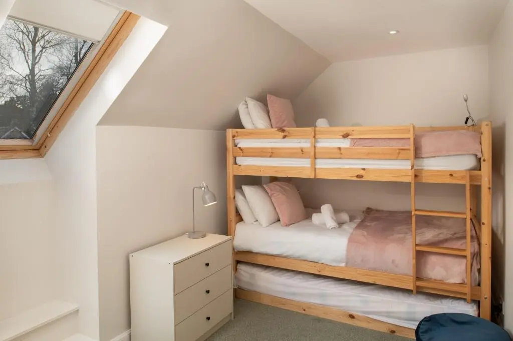 a bedroom with two bunk beds in a attic at Anne's Place in Boat of Garten
