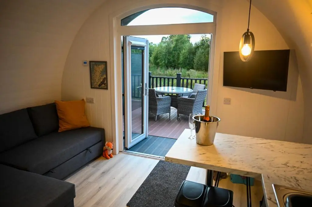 a living room with a couch and a table at Newmore Highland Pods with Hot Tubs on NC500 in Invergordon
