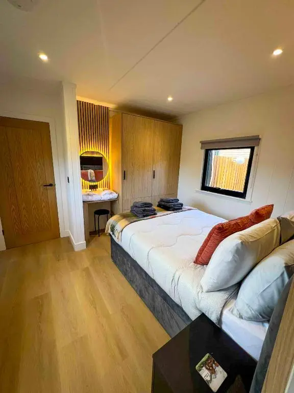 a bedroom with a large bed and a desk at Newmore Highland Pods with Hot Tubs on NC500 in Invergordon