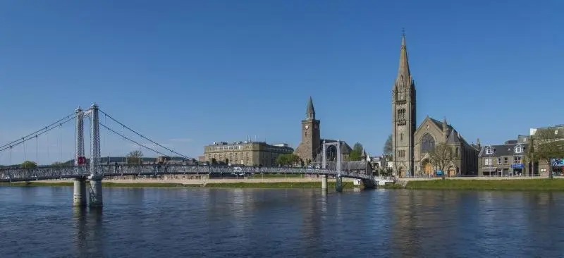 a bridge over a river next to a city at Stephen's Street Apartment, Inverness City Centre in Inverness