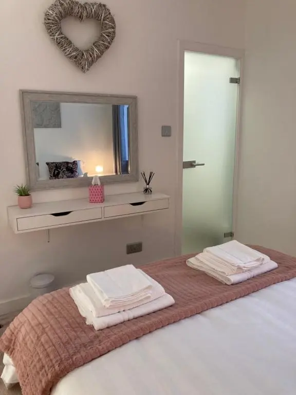 a bedroom with a bed with a mirror and towels at Haugh Ness in Inverness