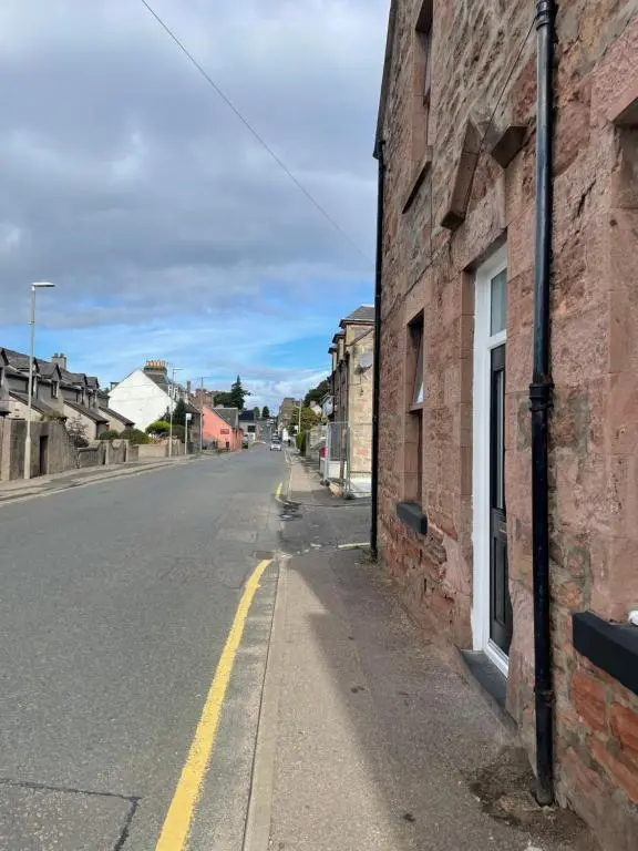 an empty street next to a brick building at Haugh Ness in Inverness