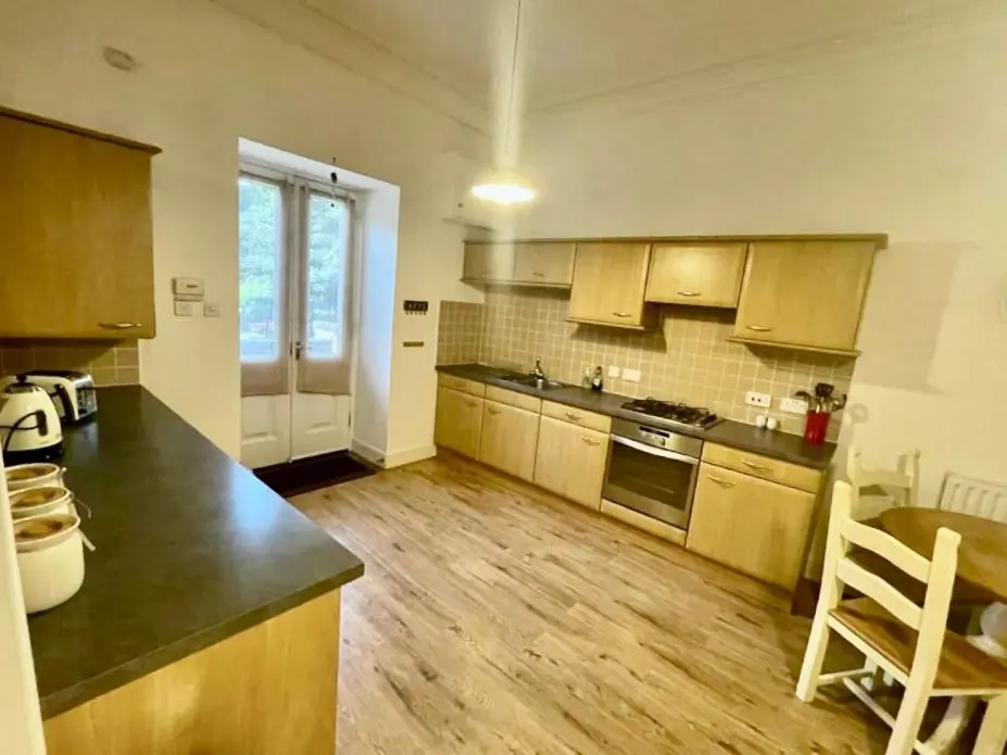 a kitchen with wooden floors and a counter top at Serviced Accommodation Moray - Lesmurdie House No 2 in Elgin
