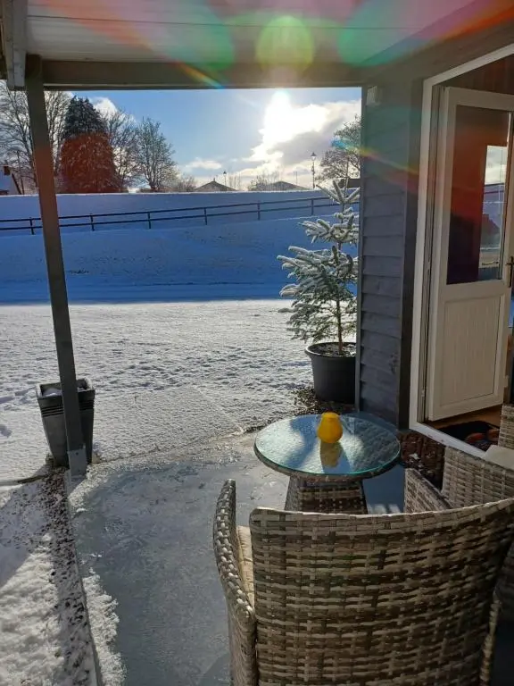 a glass table with an orange on it on a patio at Erraid Lodge in Fort Augustus