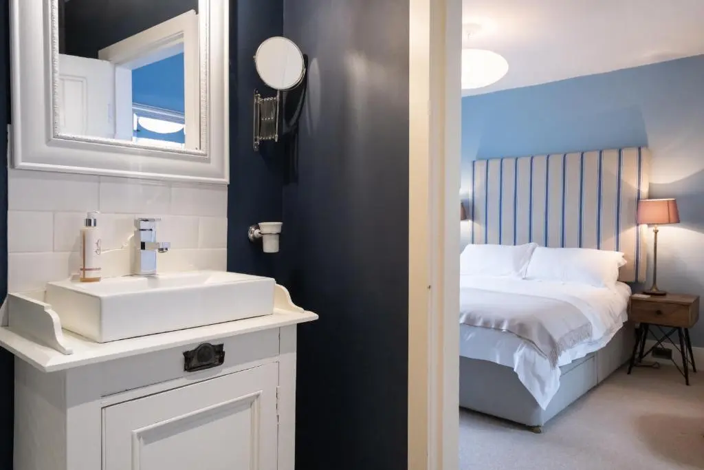 a bathroom with a white sink and a bed at Seaside cottage on Moray coast in Portknockie