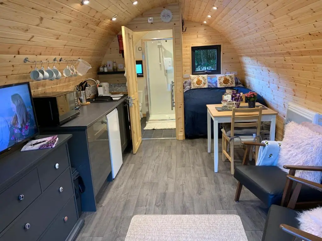 a kitchen and dining room in a tiny house at Loch Ness Woodland Pods in Drumnadrochit