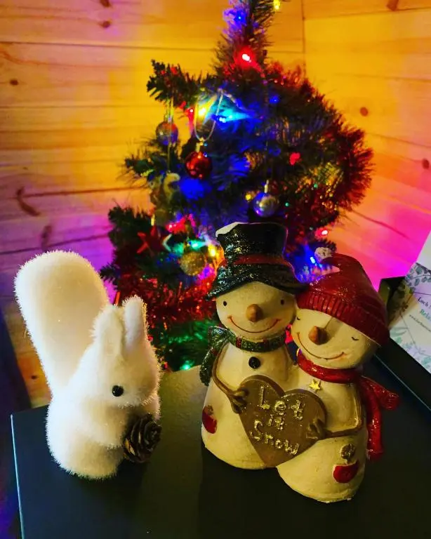 two snowmen and a rabbit next to a christmas tree at Loch Ness Woodland Pods in Drumnadrochit