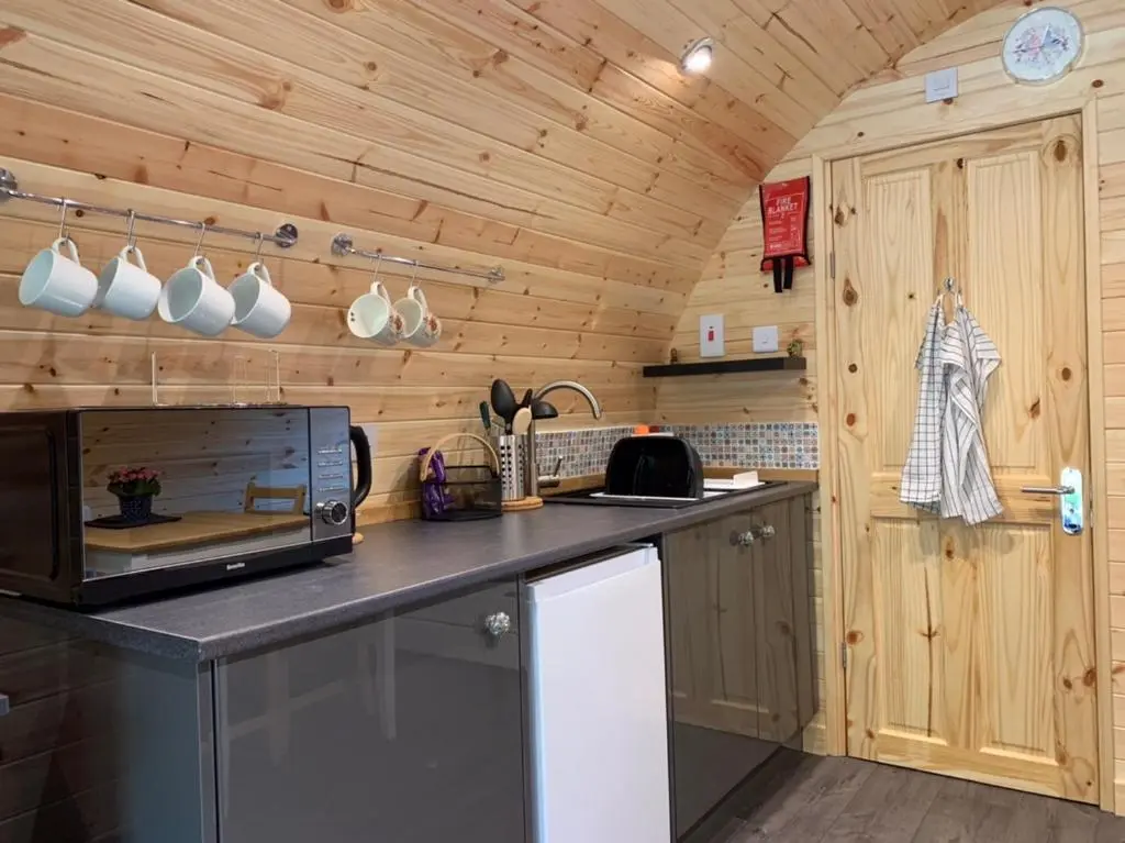 a kitchen with wooden walls and a counter top at Loch Ness Woodland Pods in Drumnadrochit