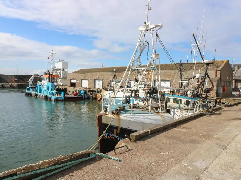 two boats docked at a dock in the water at RockStar Cottage in Macduff