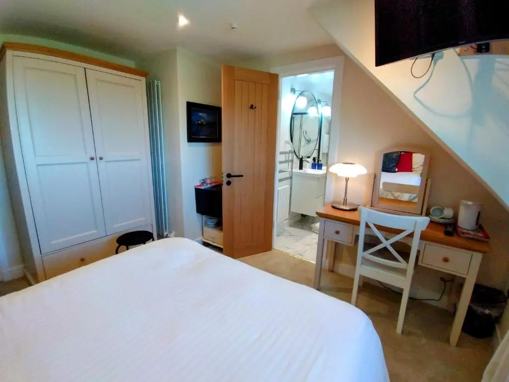a bedroom with a bed and a desk with a table at Aber Holiday Rentals in Inverness