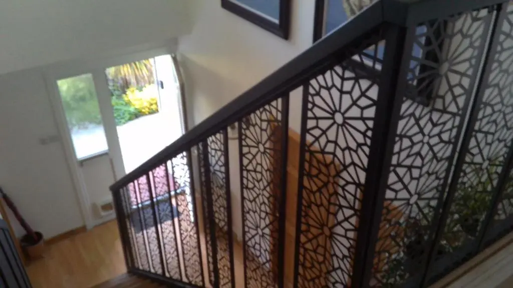 a staircase with a wrought iron railing and a door at Aber Holiday Rentals in Inverness