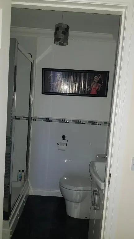a bathroom with a toilet and a tv on the wall at Aber Holiday Rentals in Inverness