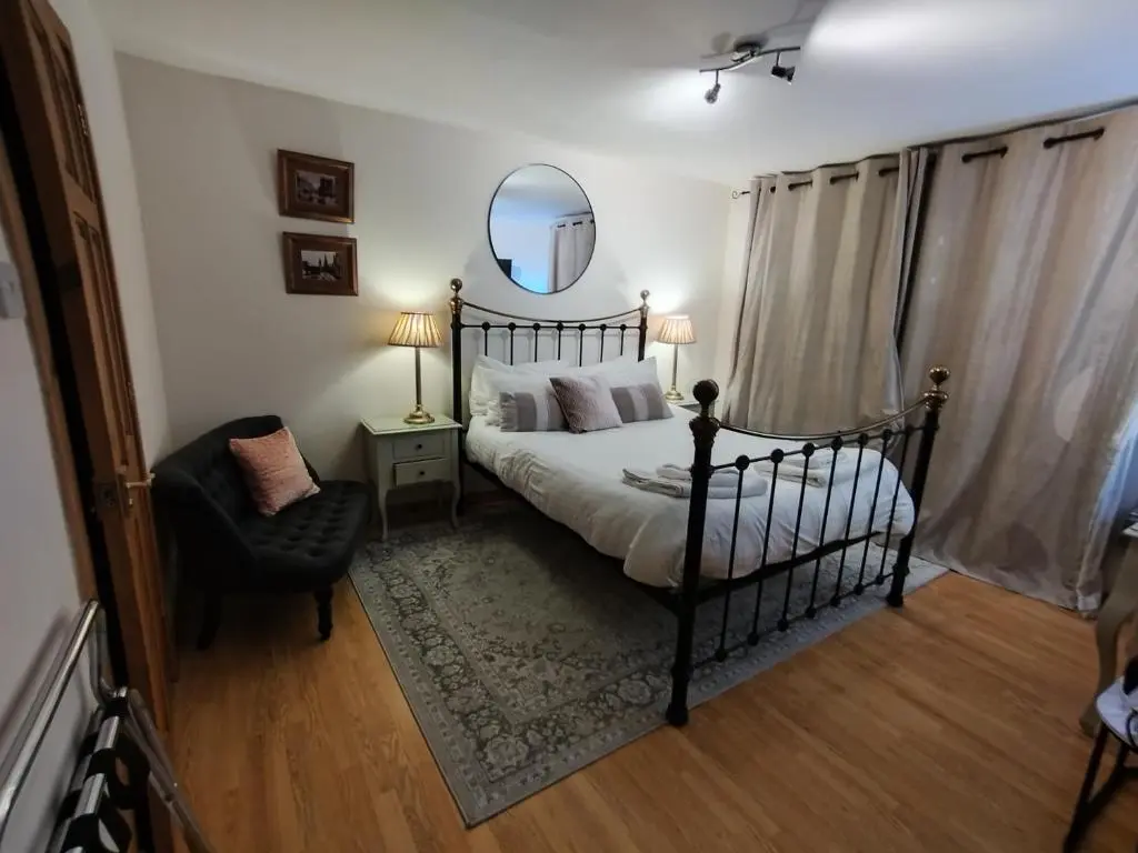 a bedroom with a bed and a mirror and a chair at Aber Holiday Rentals in Inverness