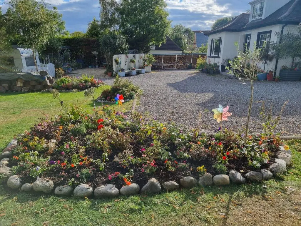 a garden with a flower bed in the yard at Nannys tiny hoose in Inverness
