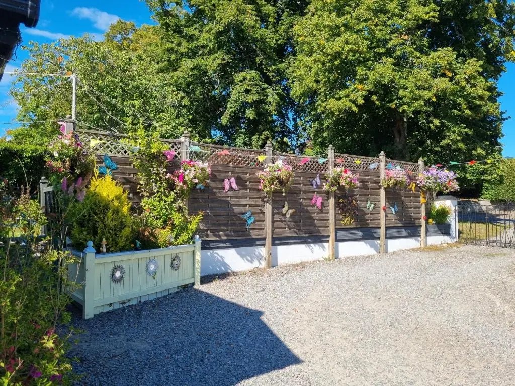 a garden with flowers on a wooden fence at Nannys tiny hoose in Inverness