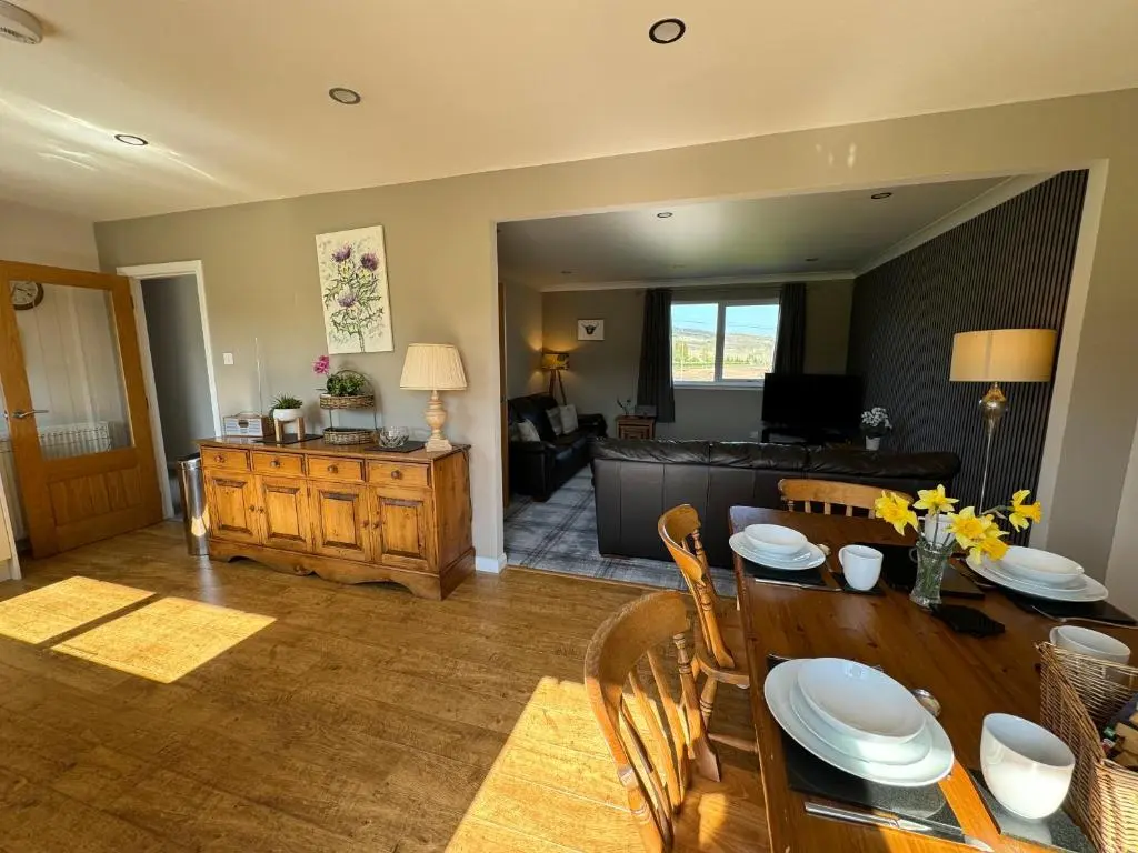 a living room with a table and a couch at Drumhead Cottage Finzean, Banchory Aberdeenshire Self Catering with Hot Tub in Finzean