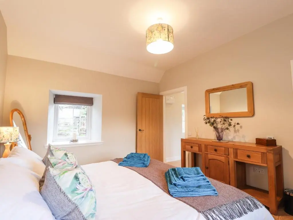 a bedroom with a bed and a mirror and a dresser at Bonnach in Muir of Ord
