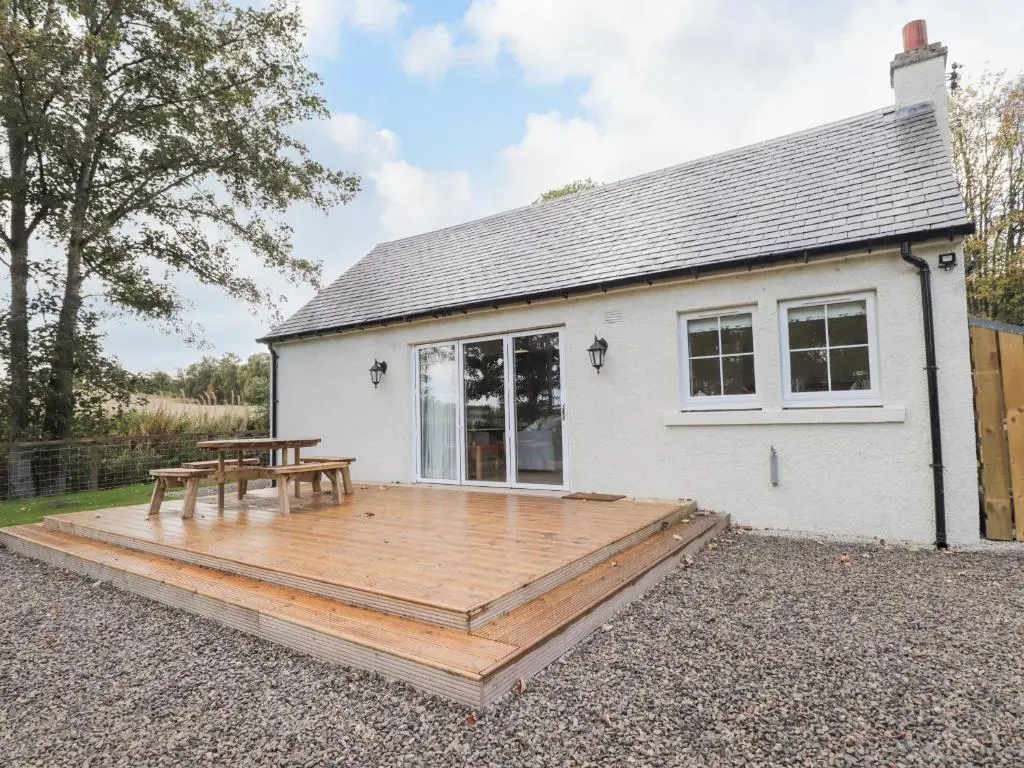 a house with a wooden deck in front of it at Bonnach in Muir of Ord