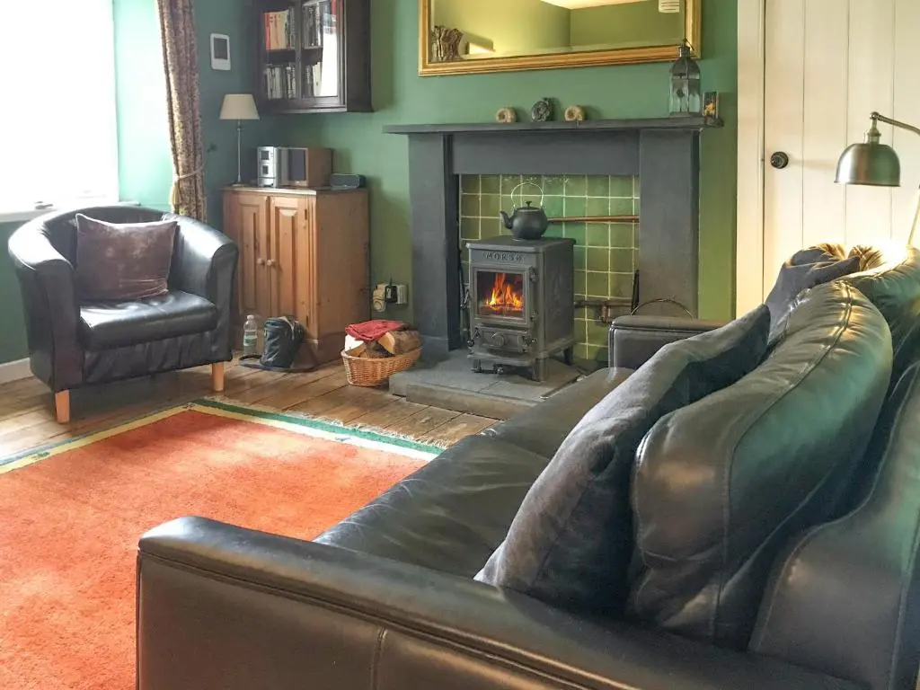 a living room with a couch and a fireplace at Tigh Beag in Newtonmore