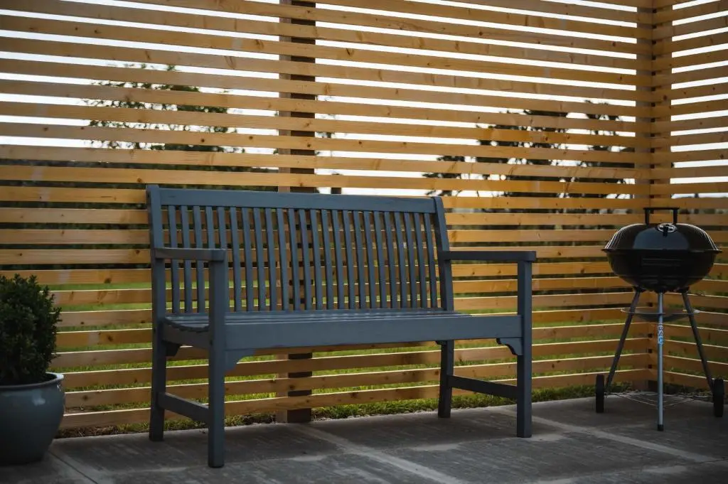 a blue bench sitting in front of a wooden wall at Drumdry in Wick