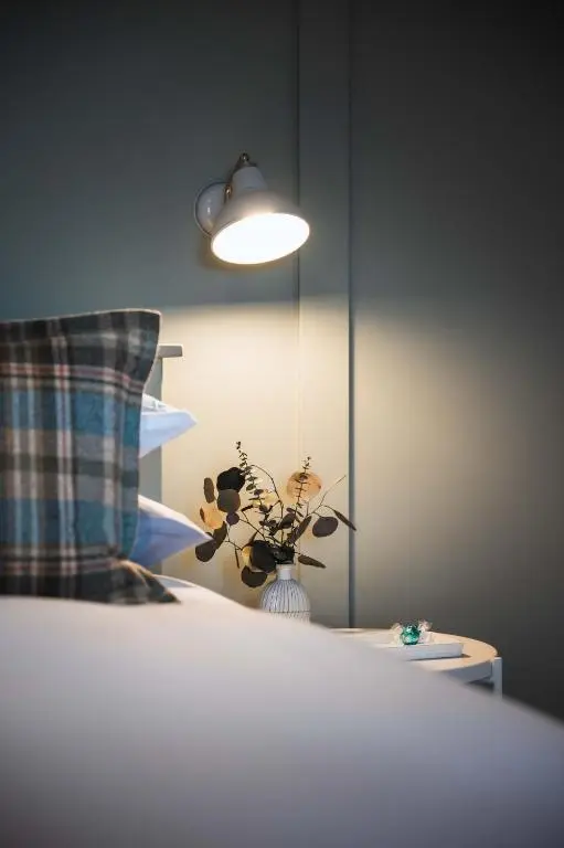 a bed with a pillow and a vase with flowers at Drumdry in Wick