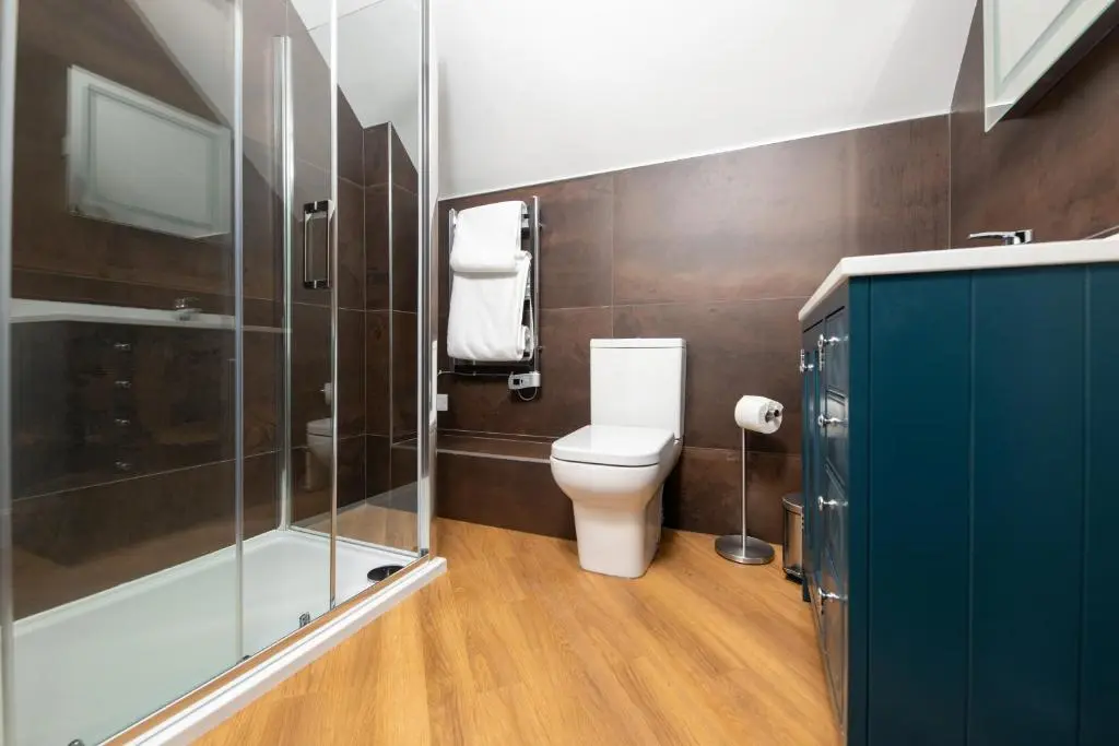 a bathroom with a toilet and a glass shower at Lock Keepers Cottage, Loch Ness Cottage Collection in Inverness