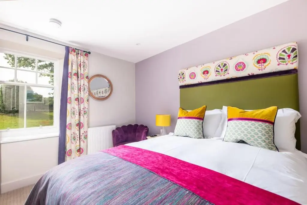 a bedroom with a large bed and a window at Lock Keepers Cottage, Loch Ness Cottage Collection in Inverness