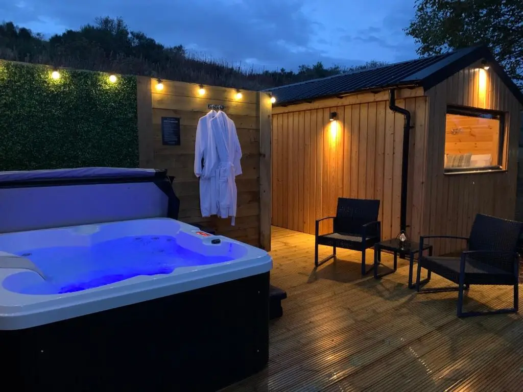 a bath tub sitting on top of a wooden deck at River Huts with Private Hot Tubs in Inverness