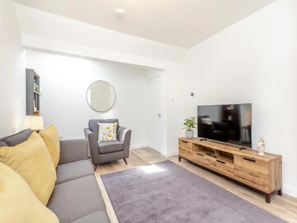a living room with a couch and a flat screen tv at Dove Cottage in Inverness
