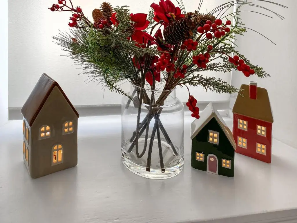 a vase with flowers and houses on a table at Dove Cottage in Inverness