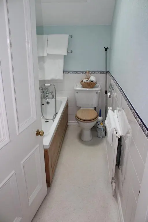 a bathroom with a toilet and a tub and a sink at Moyness House in Inverness