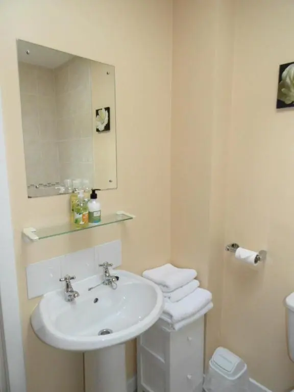 a bathroom with a sink and a toilet and a mirror at Moyness House in Inverness