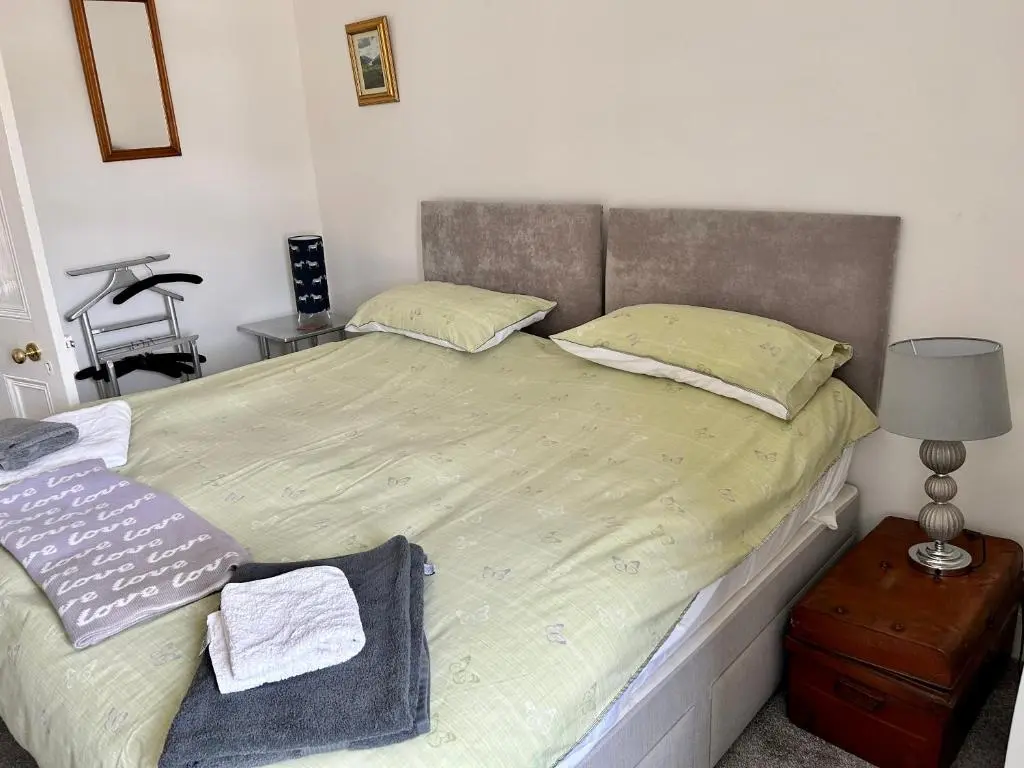 a bedroom with a large bed with a headboard at Lottie\u2019s Cottage, Rhynie, Aberdeenshire in Rhynie