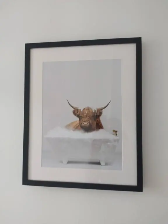 a framed picture of a bull in the snow at Lottie\u2019s Cottage, Rhynie, Aberdeenshire in Rhynie
