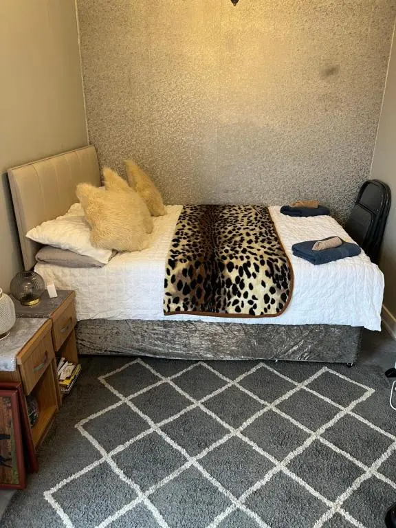 a bedroom with a bed with a leopard print at Craigellachie Cabin in Aviemore