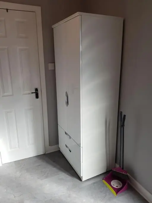 a white cabinet in a room with a door at Craigellachie Cabin in Aviemore