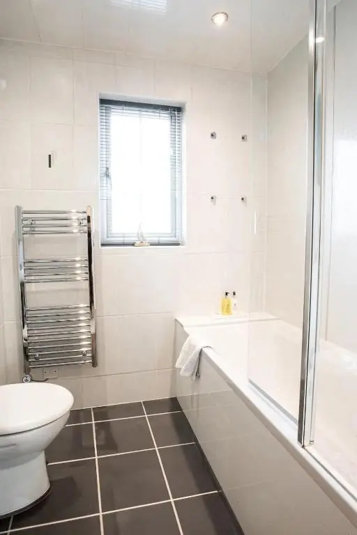 a bathroom with a toilet and a tub and a sink at Apartment No16 in Inverness