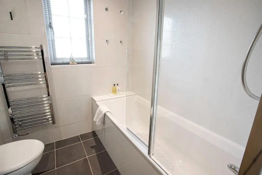 a bathroom with a shower and a tub and a toilet at Apartment No16 in Inverness