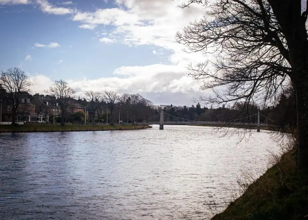 a view of a river with a bridge in the background at Apartment No16 in Inverness