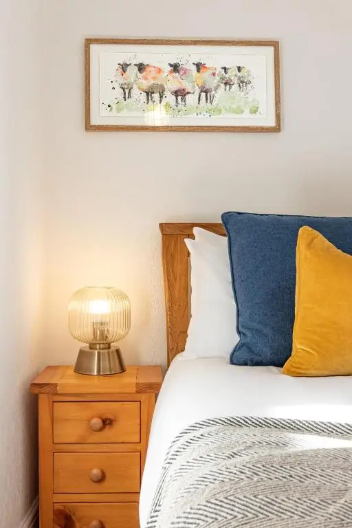 a bedroom with a bed and a picture on the wall at Thistle do Nessly in Inverness