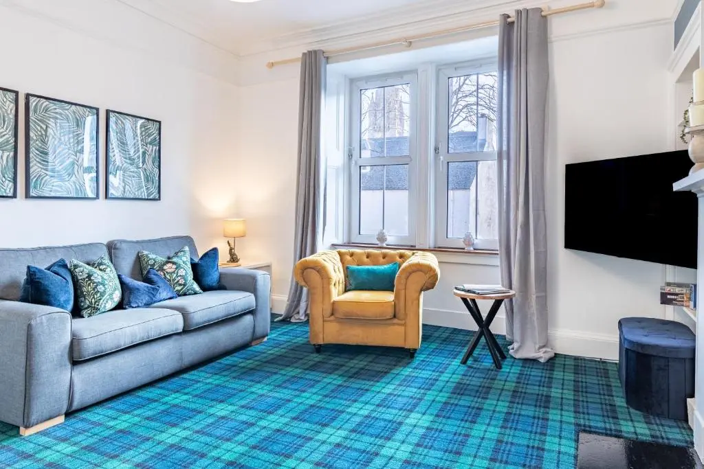a living room with a couch and a tv at Thistle do Nessly in Inverness