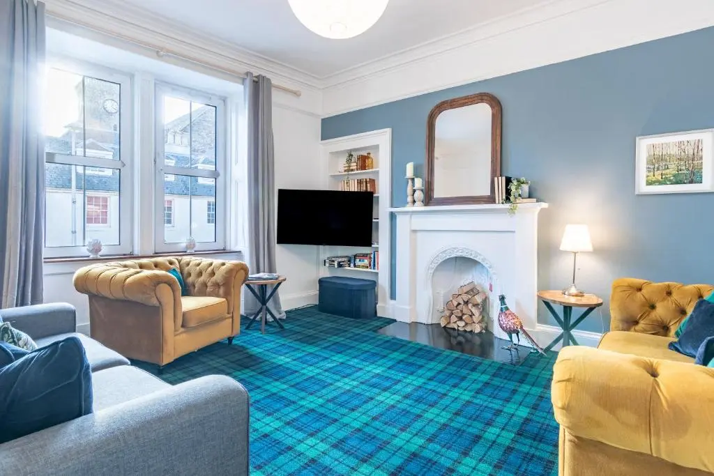 a living room with two couches and a fireplace at Thistle do Nessly in Inverness